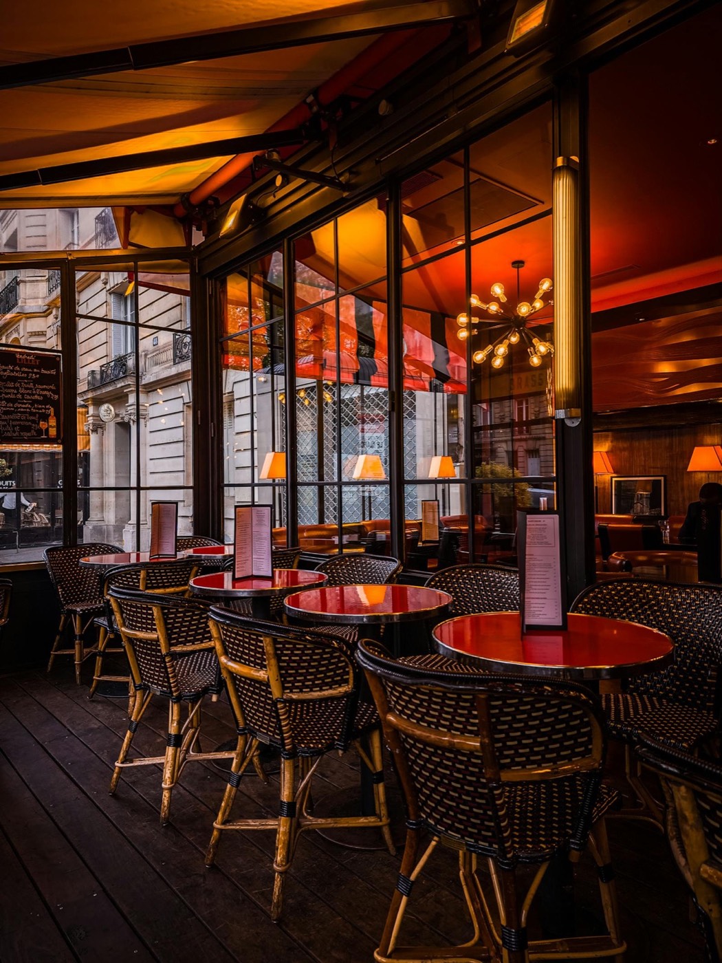 Salle de bistrot Chez Jeanne, tables rouges et lumière chaude en vieille ville d'Antibes