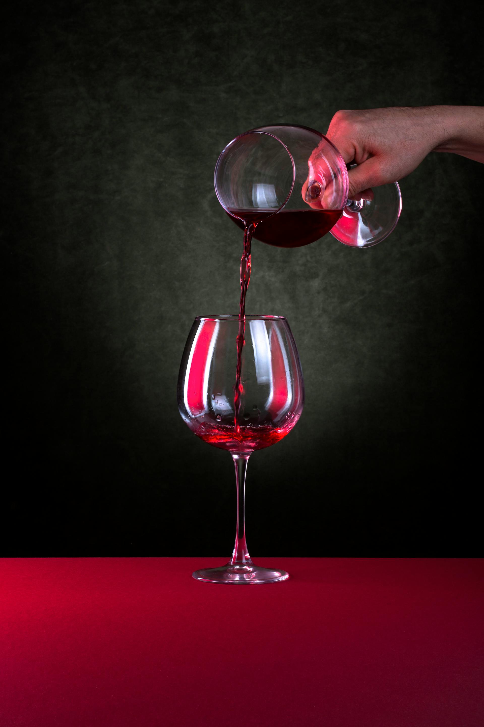 Vin rouge versé dans un verre, ambiance contre-jour